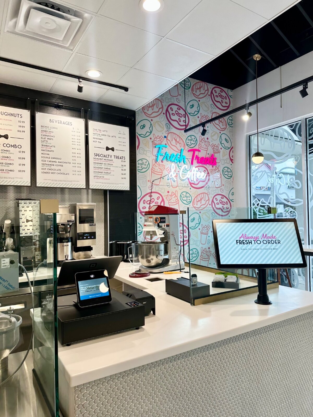 Dapper Doughnut storefront counter with penny-tile front, menu boards and the Fresh Treats and Coffee neon