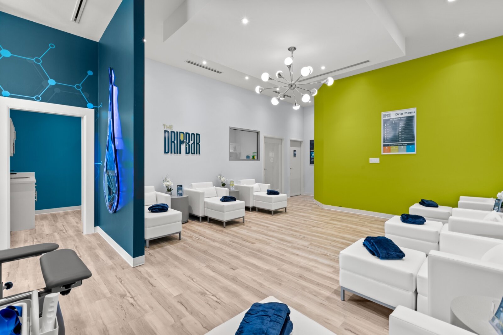 THE DRIPBaR treatment lounge with white recliners and the brand wall